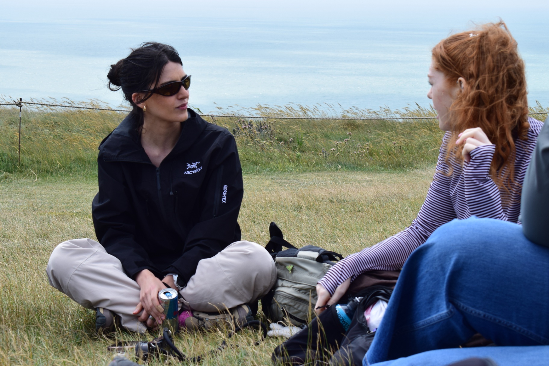 Two women laughing together at a sunlit picnic